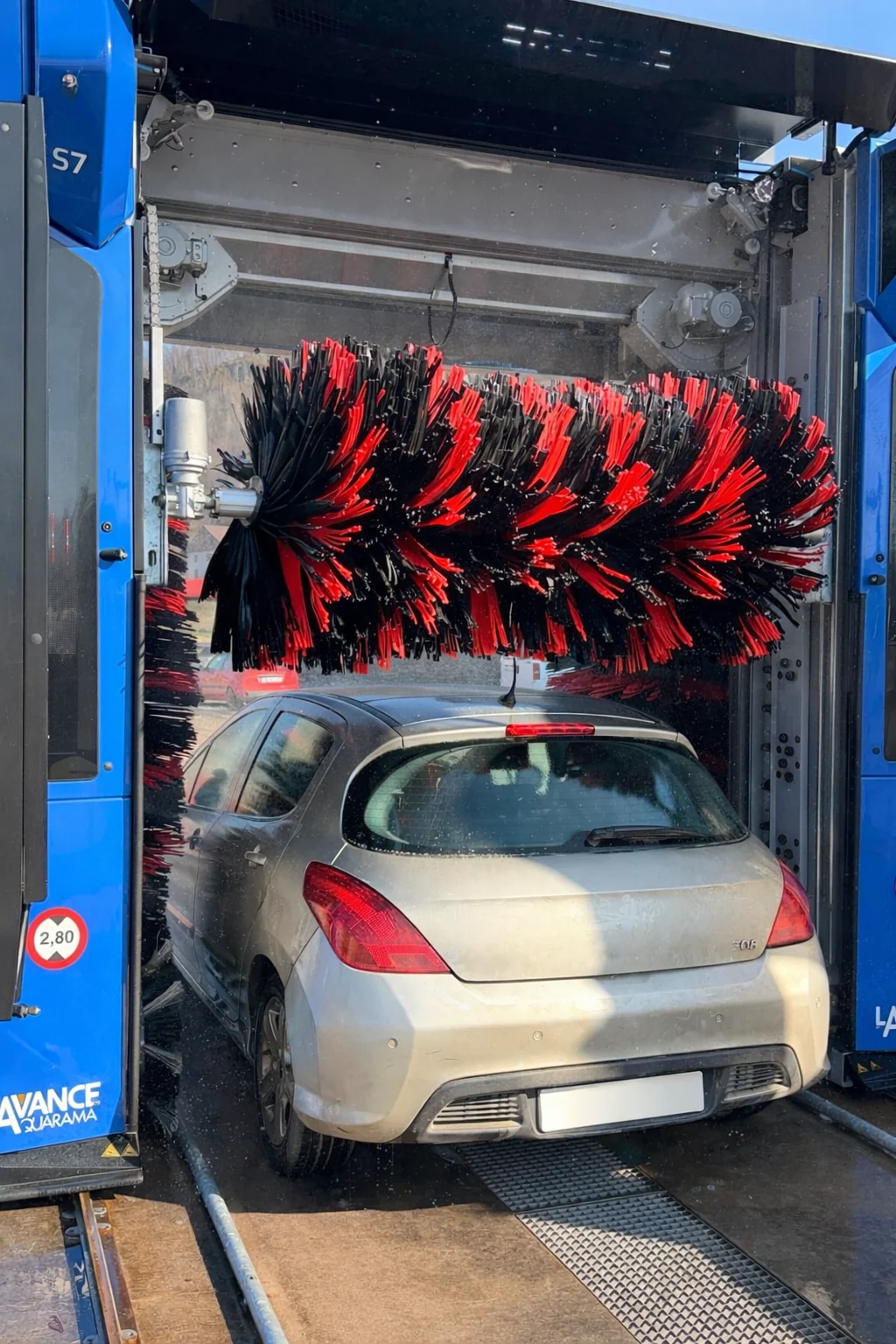 Une voiture au lavage sous les brosses du portique S7